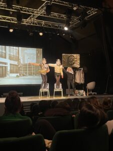 groupe de comédiens sur scène avec des pancartes