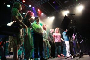 un groupe de personnes chante sur scène